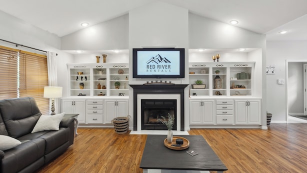 A modern living room with a fireplace, white cabinetry, and a television displaying 'Red River Rentals'. - Hatton Hideaway at Red River Gorge! Pool / Hot Tub / Arcade Game Room (Stanton)