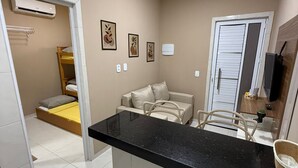 A compact living space with a kitchenette, a bed, a sofa, and a small dining area.