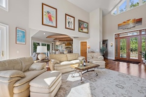A spacious living room with a large sofa, a coffee table, and artwork on the walls.