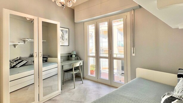 Une chambre à coucher avec un lit, un bureau et une armoire.