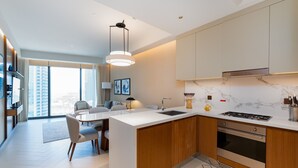 Une cuisine moderne dotée d’un îlot central, d’un four encastré et d’une grande fenêtre offrant une vue sur la ville.