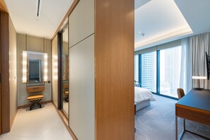 A hotel room with a large bed, a desk, a mirror, and a view of the city. - 2BR Address Dubai Opera | Walk to Mall, Burj Khalifa & Opera (Dubai)