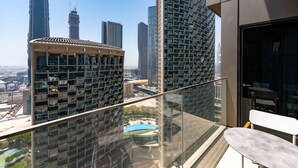 Un immeuble de grande hauteur doté d’un balcon en verre, offrant une vue sur un paysage urbain avec plusieurs gratte-ciel.