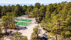 A tennis court surrounded by dense forest. - Hölick Minichalet Plus 6 by Interhome (Hölick)