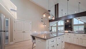 A spacious kitchen with white cabinetry, granite countertops, and pendant lighting. - "Fitz-Just-Right" home in Walden: Boat ramp, Pickleball, Community Pools! (Montgomery)
