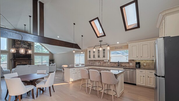 A spacious kitchen with a large island, white cabinetry, and a modern pendant light fixture. - "Fitz-Just-Right" home in Walden: Boat ramp, Pickleball, Community Pools! (Montgomery)