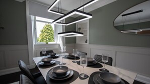 A dining area with a rectangular table set for six, black plates, and clear glasses. - Penthouse at the White House near Edinburgh (Bathgate)
