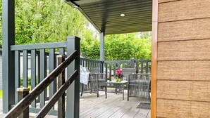 A wooden deck with outdoor furniture, a covered area, and a view of greenery. - Vacation home Joschi by Interhome (Plau am See)