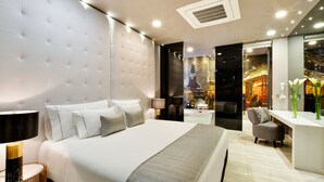 Ein modernes Hotelzimmer mit einem großen Bett, einem Schreibtisch und einem Stuhl.