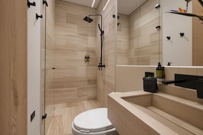 A modern bathroom with a shower, toilet, and vanity.