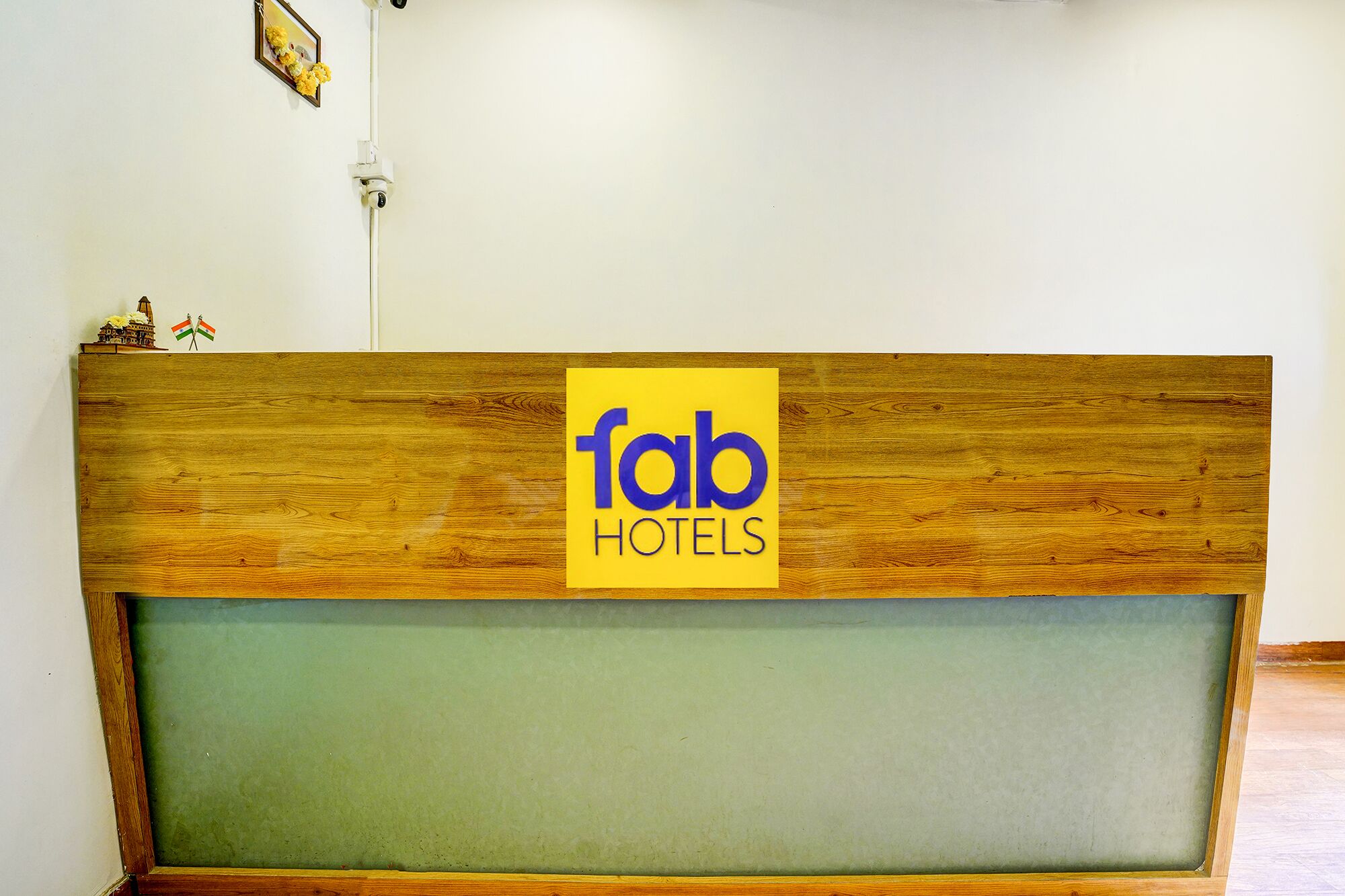 A reception desk with a wooden top and a yellow sign that reads "fab hotels".