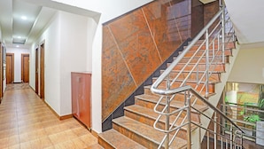 A staircase with metal railings and a wooden floor leading to a landing. - FabHotel Emerald Suites - Near MG Road Metro Station (Bangalore)