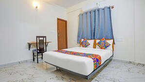 Una habitación de hotel con cama, escritorio y silla.