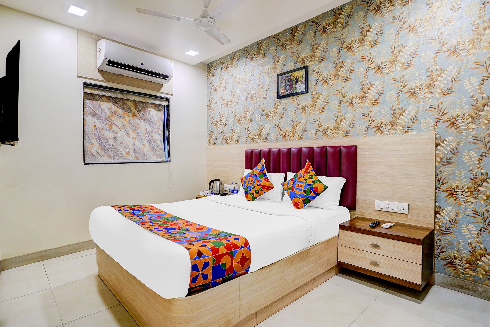 A modern bedroom with a bed, nightstand, and a wall-mounted air conditioner.