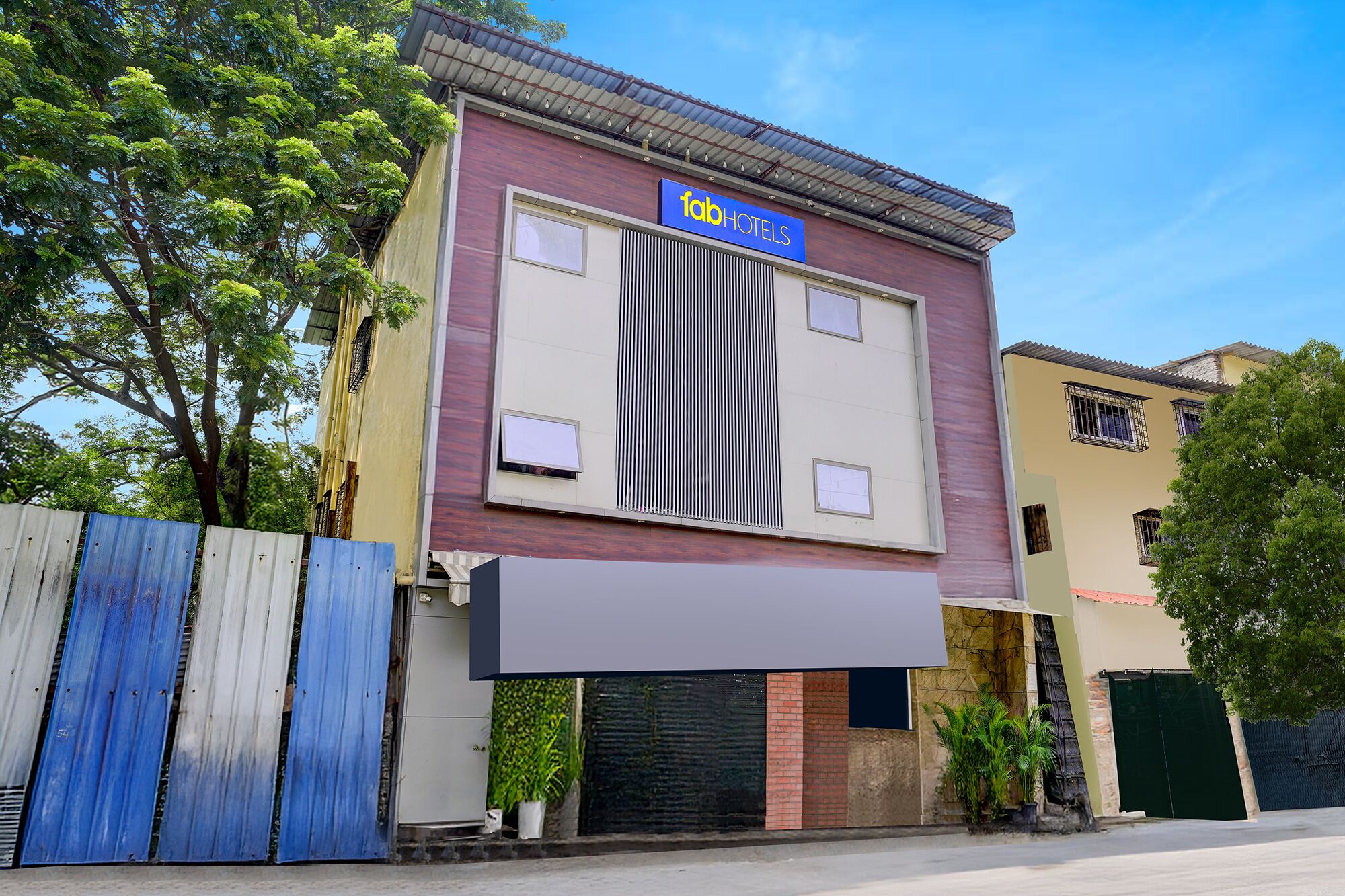 A building with a 'fab hotels' sign, a large window, and a gated entrance.