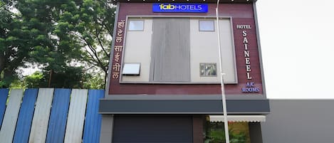 A modern building with a sign for 'fab hotels' and 'hotel saineel' indicating A/C rooms.