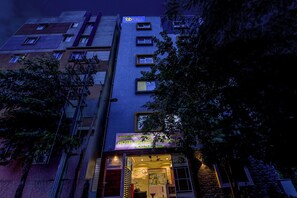 A multi-story hotel with a sign indicating it offers both AC and non-AC rooms. - FabHotel Golden Grand Inn - Global Village (Bangalore)