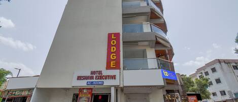A multi-story building with a sign for 'Hotel Keshava Executive' and 'Lodge' indicating it offers rooms and possibly other accommodations.