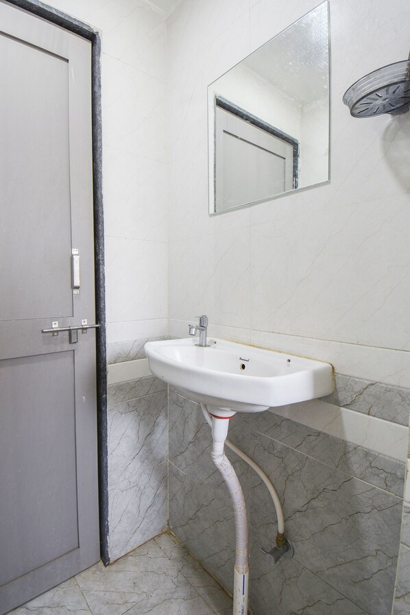 A bathroom with a white sink, a mirror, and a door. - Fabhotel Keshava executive - Nr Mahadji Shinde chhatri (Pune)