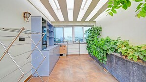 Un appartement moderne doté d’un balcon, de grandes fenêtres et offrant une vue sur la ville.