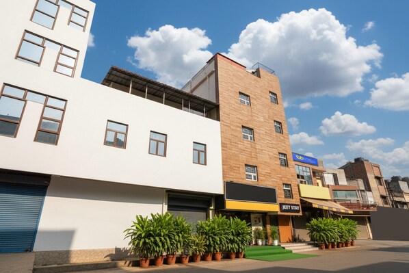 A multi-story building with a flat facade, a visible storefront with a sign for 'Jeet Stay', and several potted plants in front. - Fabhotel Jeet Stays (New Delhi)