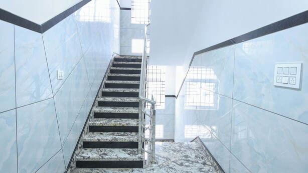 A staircase with marble walls and handrails, leading to a higher floor. - FabHotel Golden Comforts (Bengaluru)