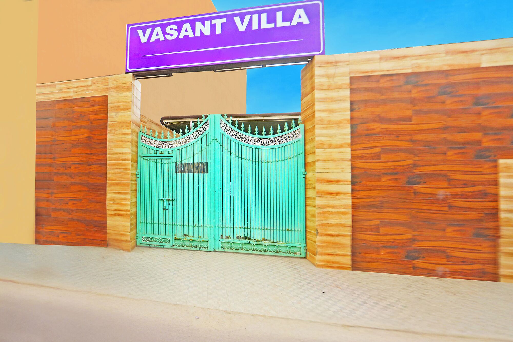 A gated entrance with a sign reading "VASANT VILLA".