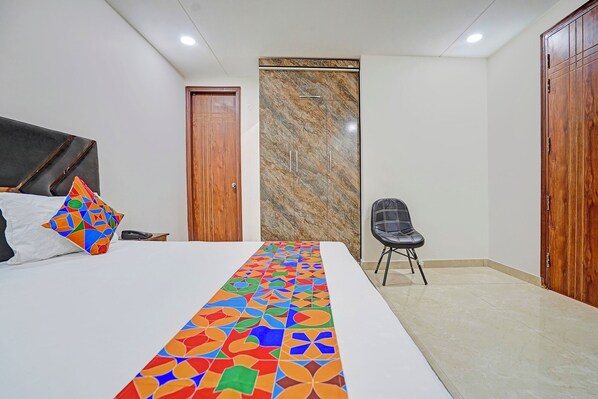 A bedroom with a bed, a chair, and a wardrobe. - Fabexpress Lotus Longue (Faridabad)