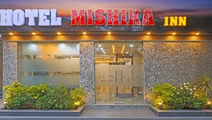 En hotellentrén med en skylt som visar texten ”HOTEL MISHIKA INN”.