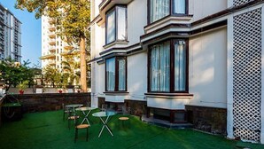 Edificio residencial con un pequeño patio que tiene césped y muebles de exterior.