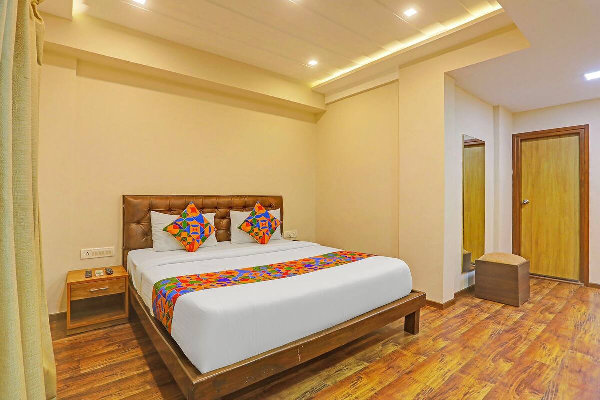 A neatly arranged bedroom with a large bed, a bedside table, and a wooden nightstand.