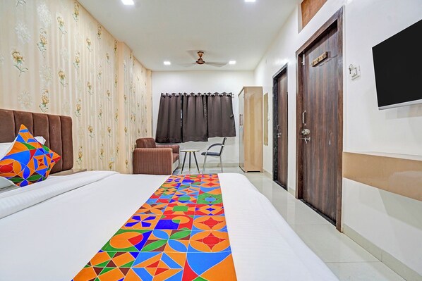 A hotel room with a bed, a desk, a chair, and a wardrobe. - FabHotel Amrit Palace - Opp. Skye Corporate park (Indore)