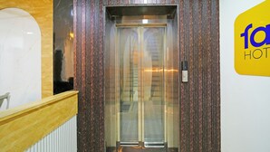 An elevator with a metallic interior and a wooden panel wall. - Fabhotel Ss Inn (Indore)