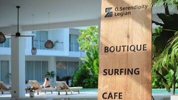 Un letrero de madera con la inscripción 'Boutique Surfing Cafe' y 'O.Serendipity Legion'.