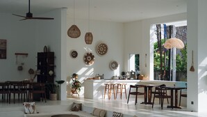 A spacious living area with a kitchen, dining area, and seating space. - Serendipity Legian (Legian)