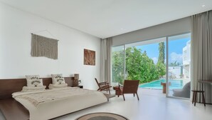 A modern bedroom with a large bed, a view of a swimming pool, and a balcony. - Serendipity Legian (Legian)