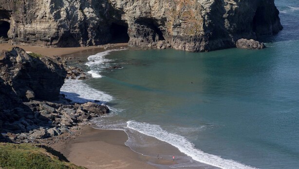 A coastal landscape with a rocky beach, cliffs, and calm sea. - Kudhva 3 (Tintagel)