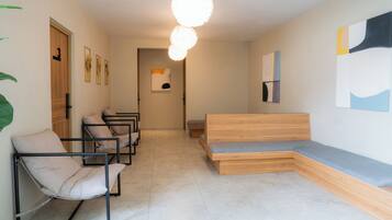 A modern waiting area with a bench, chairs, and artwork on the walls.