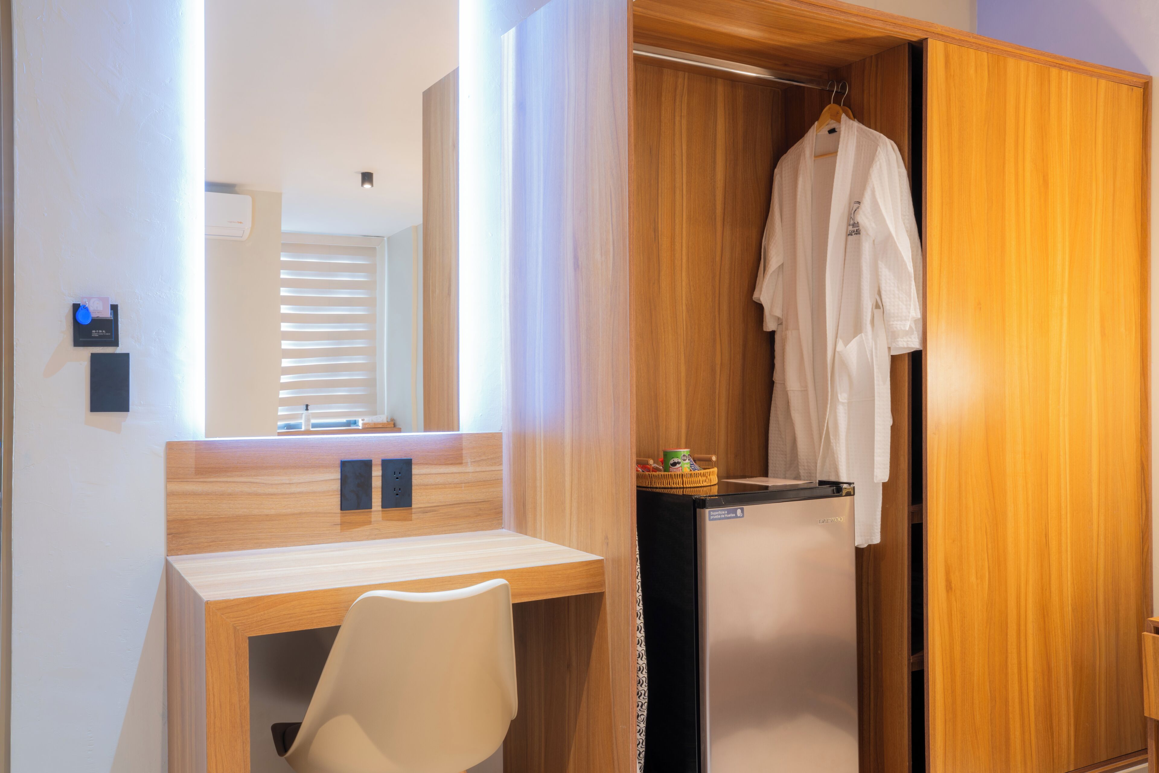 A modern bathroom with a wooden vanity, a mirror, and a towel rack.