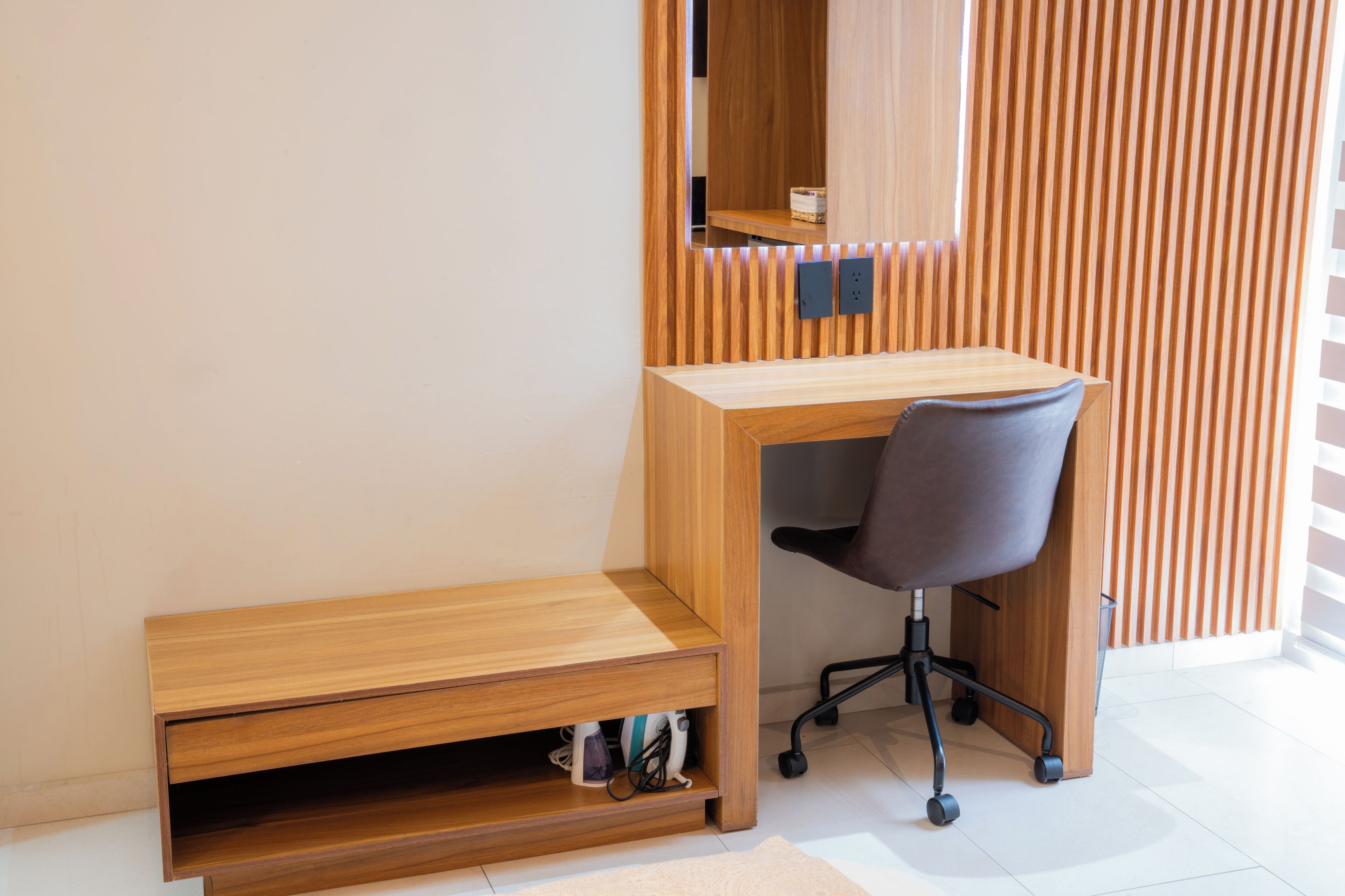 Un espace de bureau moderne comprenant un bureau en bois, une chaise et une petite étagère.