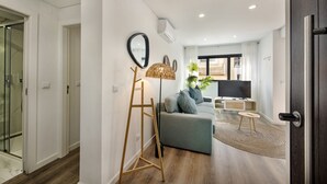 Een moderne woonkamer met een bank, een televisie en een vloerlamp.