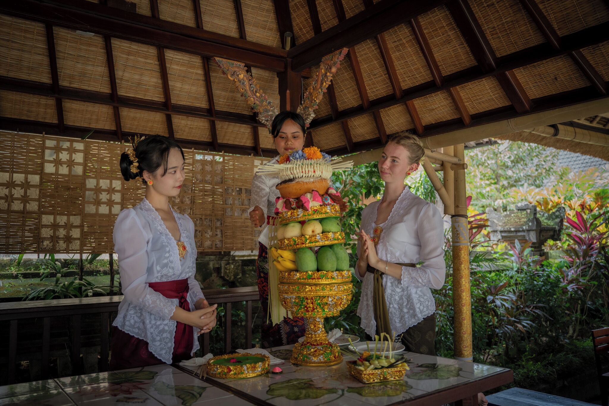 A traditional ceremony with a decorated table and participants in cultural attire.