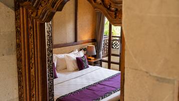 A bed with a headboard, pillows, and a blanket.