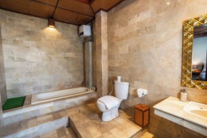Un baño con bañera, inodoro y lavamanos.