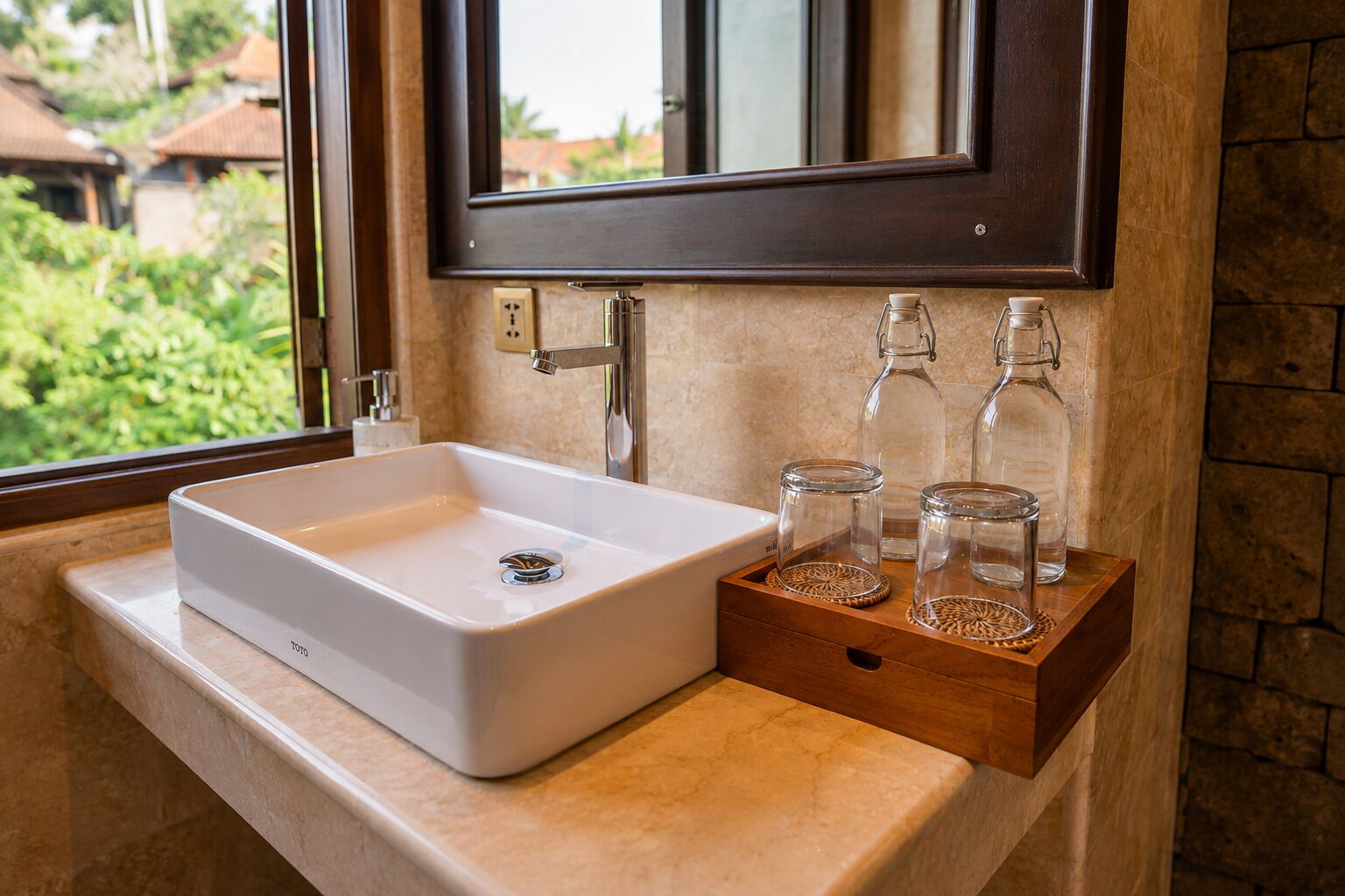 Un baño con un lavamanos blanco, un espejo y una estantería de madera con botellas de vidrio.