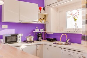A compact kitchen with white cabinets, a microwave, a coffee maker, and a sink. - Charming Downtown Studio, Zagreb, Croatia (Zagreb)