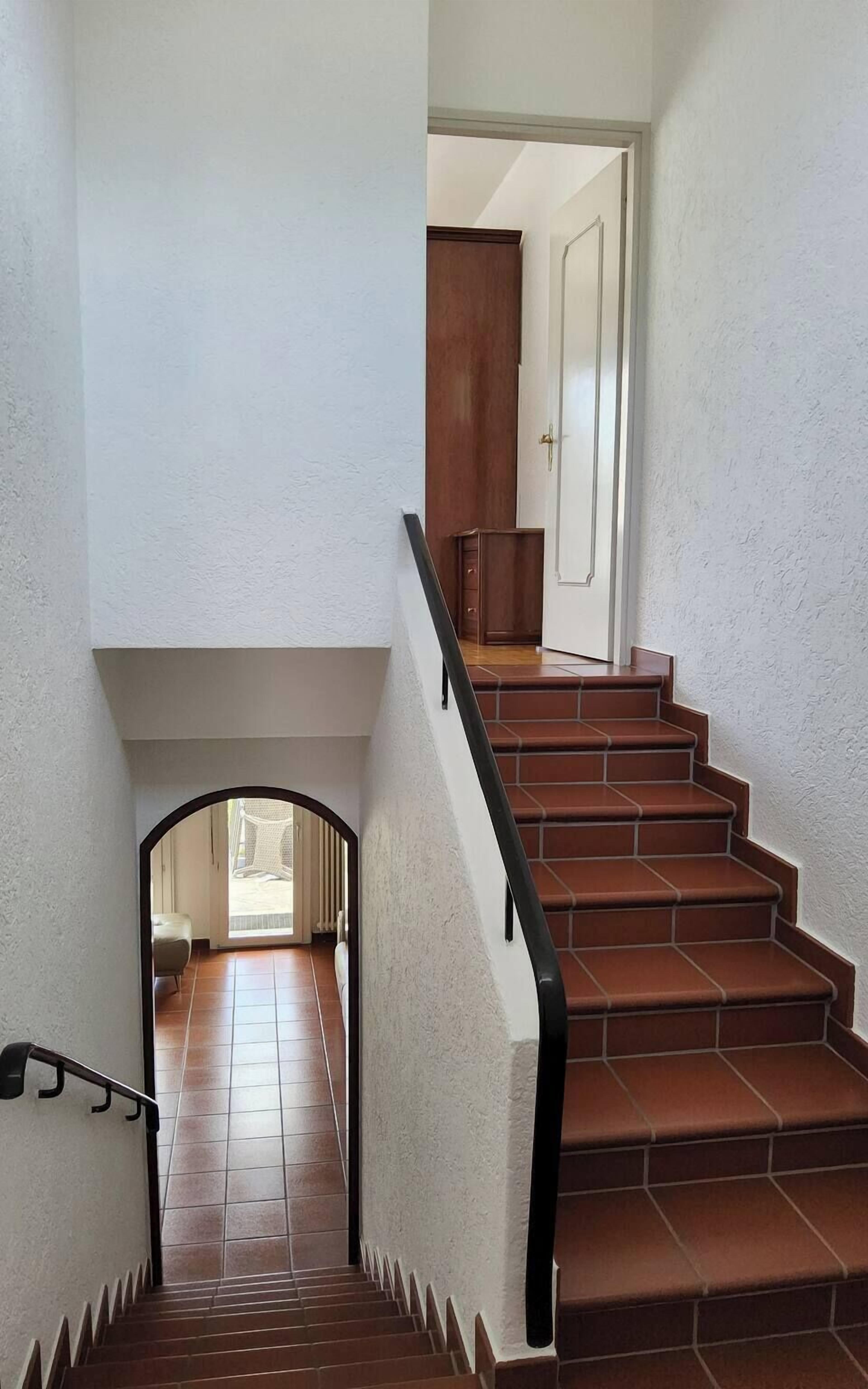 Eine Treppe mit Handlauf, die zu einer Tür führt.