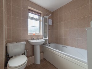 A bathroom with a toilet, sink, and bathtub. - The Birches by Interhome (Liskeard)