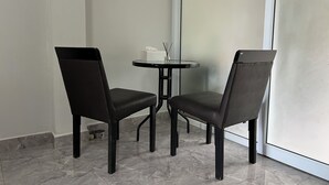 A room with two black chairs and a small round table, a tissue box, and a bottle of water on the table. - Cozy near Samui airport (Chang Wat Surat Thani)