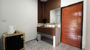 A bathroom with a sink, mirror, and a wooden door. - Cozy near Samui airport (Chang Wat Surat Thani)